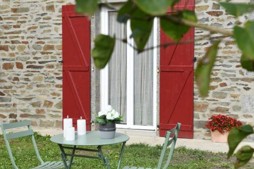 a table with candles and a window with red shutters at Gîte des champs étoilés in Thuboeuf