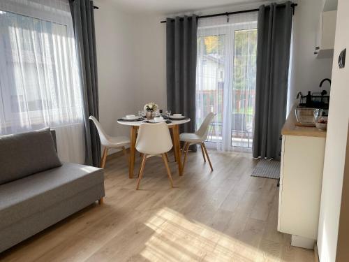 a living room with a table and chairs and a couch at Willa Torfowa in Wisła