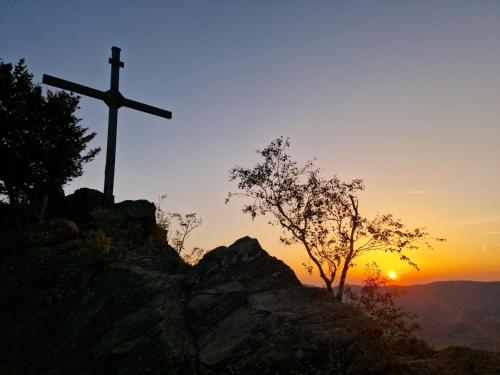 a cross on top of a mountain at sunset at Bewegung in Ruhe in Bachones