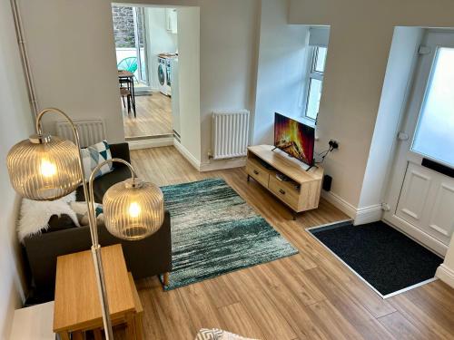 a living room with a couch and a tv at The Cottage, Bridge House in Laxey