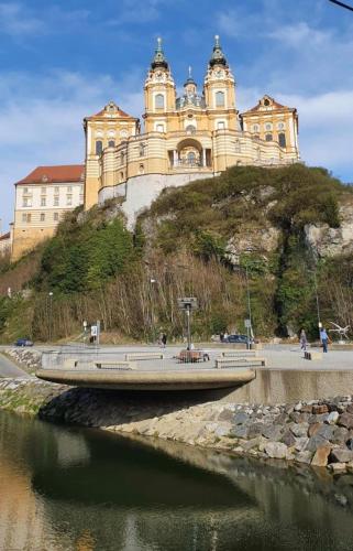 a large building on top of a hill next to a river at Bewegung in Ruhe in Bachones