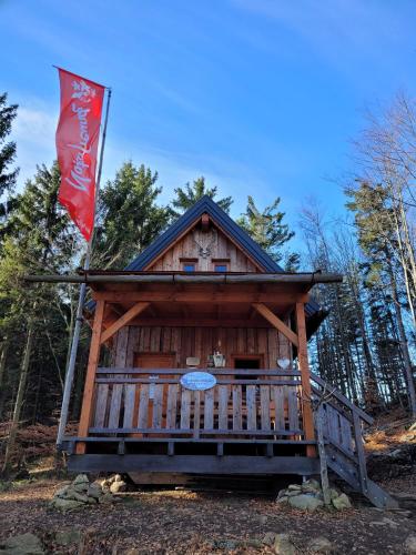 a log cabin with a flag on top of it at Bewegung in Ruhe in Bachones