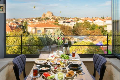 a table with food on it with a view of a city at Cappadocia Fiesta Stone House in Uchisar