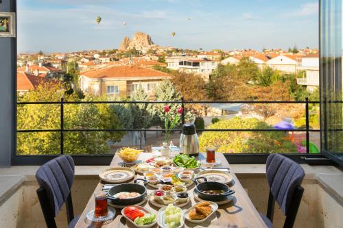 a table with food and a view of a city at Cappadocia Fiesta Stone House in Uchisar