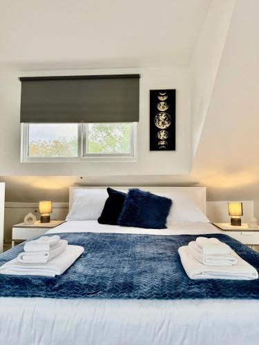 a bedroom with a bed with two towels on it at Superb Duplex in Hendon in The Hyde