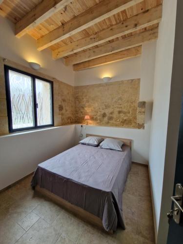 une chambre avec un lit dans une pièce avec des plafonds en bois dans l'établissement Maison agréable en pierre, à Montagne
