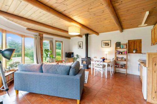 a living room with a blue couch and a table at Herons Studio - A Picturesque Couple's Cottage in Kettering
