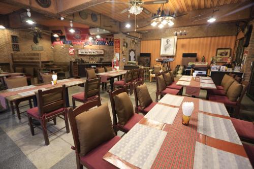 a dining room with wooden tables and chairs at Kosa Hotel & Wellness Center in Khon Kaen