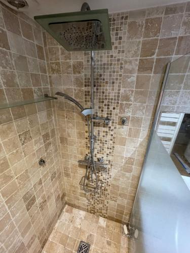 La salle de bains carrelée est pourvue d'une douche avec un pommeau de douche. dans l'établissement Petit havre de paix, à Marseille