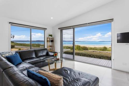 a living room with a couch and a view of the ocean at Seven Mile Beach House - Surf, Hike, Golf in Seven Mile Beach