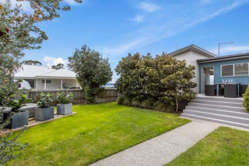 a house with a yard with grass at Seven Mile Beach House - Surf, Hike, Golf in Seven Mile Beach