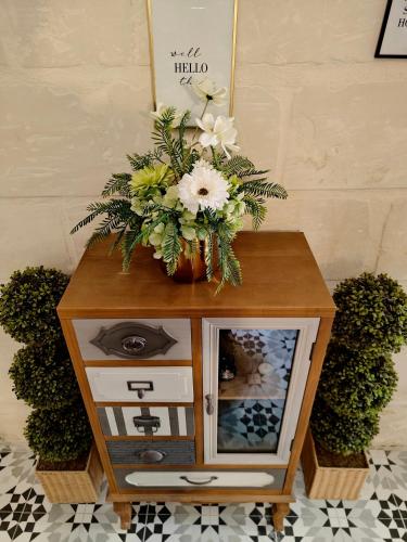 a small table with a vase of flowers on it at Cottonera Cara in Cospicua