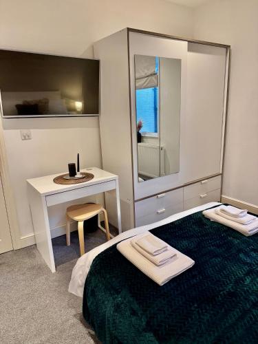 a bedroom with a bed and a table and a mirror at Superb Duplex in Hendon in The Hyde