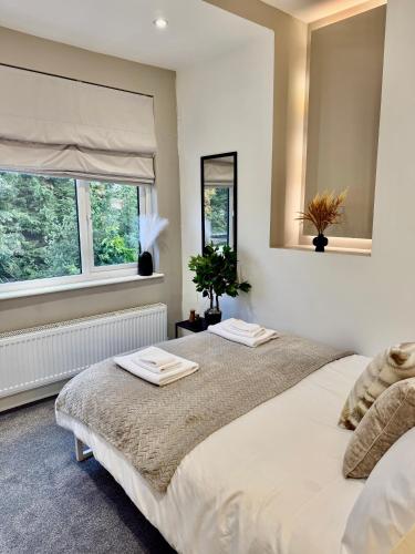 two beds in a bedroom with two windows at Superb Duplex in Hendon in The Hyde