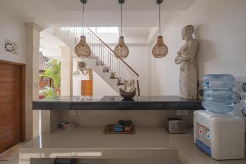 a living room with a staircase and a statue at Midep Home Stay in Ubud