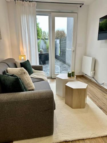 a living room with a couch and a coffee table at Studio d'Hôtes Victoire in Sainghin-en-Weppes