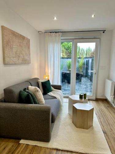 a living room with a couch and a table at Studio d'Hôtes Victoire in Sainghin-en-Weppes