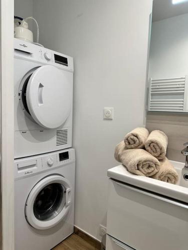 a laundry room with a washing machine and a washer at Studio d'Hôtes Victoire in Sainghin-en-Weppes