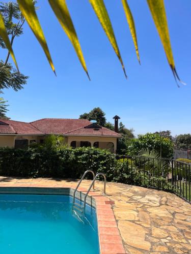 a swimming pool in front of a house at Stasumo House Arusha in Arusha