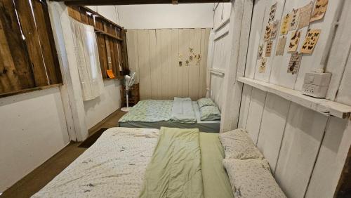 a small room with two beds in it at Panakluea at Kokuang Homestay in Ban Na Lae