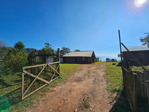 a gate on a dirt road next to a barn at Panakluea at Kokuang Homestay in Ban Na Lae