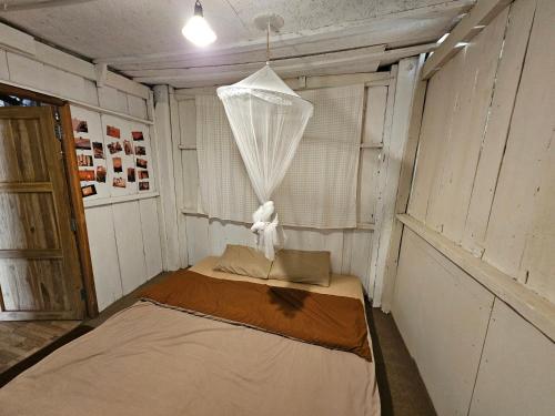 a small room with a bed with a net at Panakluea at Kokuang Homestay in Ban Na Lae