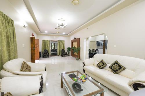 a living room with two white couches and a table at Reunion Ocean Daaffy - Beach House in Udupi