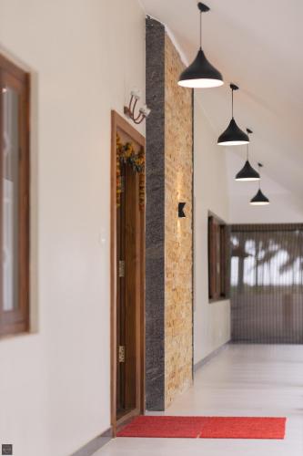 a hallway with a door and pendant lights at Reunion Ocean Daaffy - Beach House in Udupi