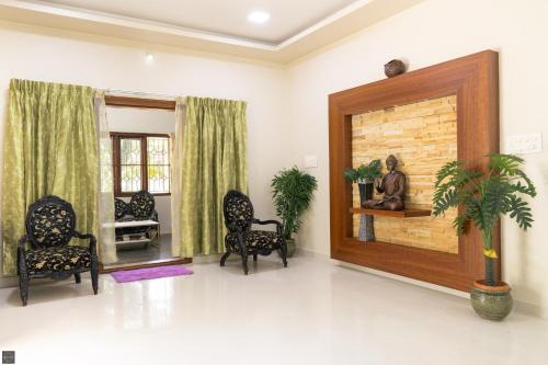 a living room with chairs and a fireplace at Reunion Ocean Daaffy - Beach House in Udupi