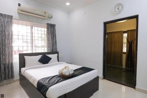 a bedroom with a bed and a clock on the wall at Reunion Ocean Daaffy - Beach House in Udupi