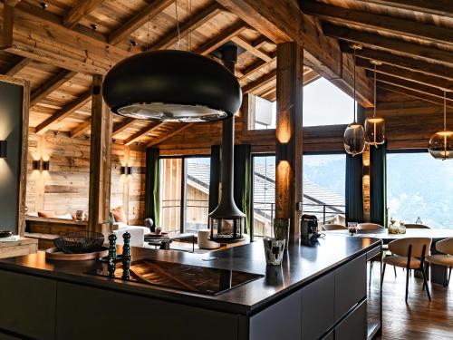 - une cuisine avec une grande île noire dans une chambre dotée de fenêtres dans l'établissement Chalet de luxe à La Plagne avec SPA, accès direct aux pistes - FR-1-755-23, à Aime La Plagne