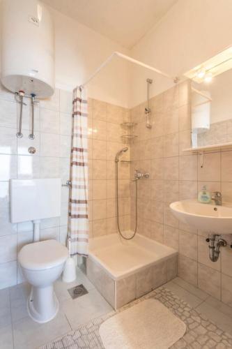 a bathroom with a toilet and a shower and a sink at Apartments Vedra in Baška Voda