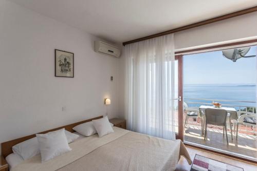 una camera da letto con un letto e vista sull'oceano di Apartments Vedra a Baška Voda