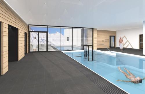 - une piscine avec une personne dans l'eau dans l'établissement Home by U - Chalet 2, à Saint-Martin-de-Belleville