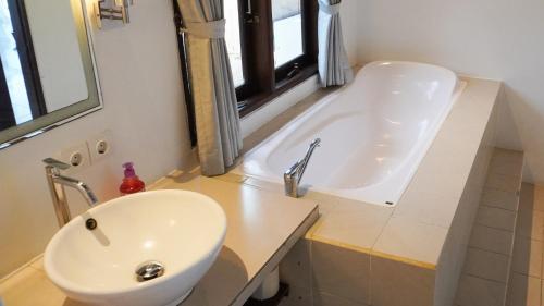 a bathroom with a sink and a bath tub at Anda Amed Villas & Spa in Amed