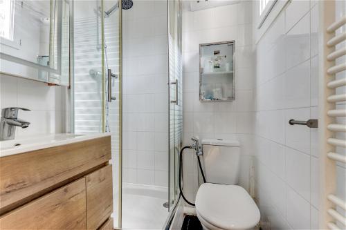 une salle de bain blanche avec toilettes et douche dans l'établissement Appartement exclusif au Parc Montsouris by Weekome, à Paris