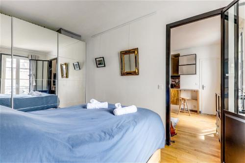 une chambre avec deux lits et un grand miroir dans l'établissement Appartement exclusif au Parc Montsouris by Weekome, à Paris