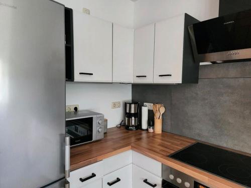 a small kitchen with white cabinets and a microwave at Lütt Bliev - Fewo in Stade in Stade