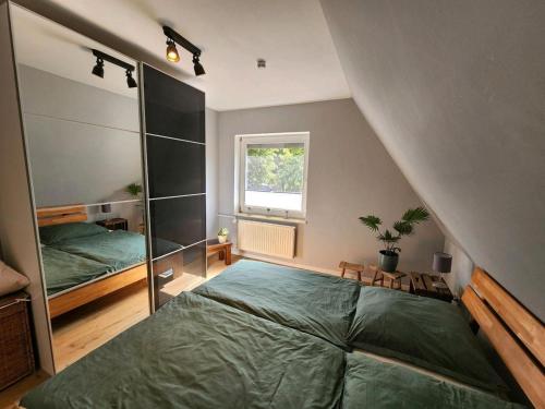 a attic bedroom with a bed and a window at Lütt Bliev - Fewo in Stade in Stade
