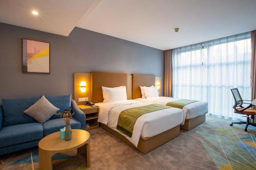 a hotel room with a bed and a couch at Holiday Inn Express Changzhou Xinbei by IHG in Changzhou