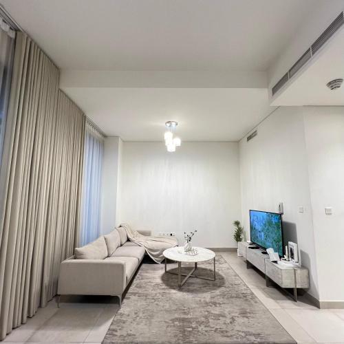 a living room with a couch and a tv at Dream Holiday Home Private Pool in Ras al Khaimah