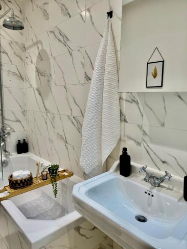 a white bathroom with a sink and a tub at Superb Duplex in Hendon in The Hyde