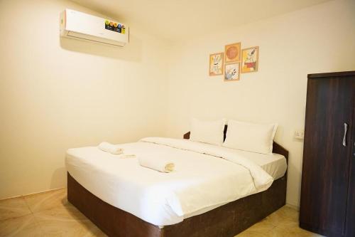 a bedroom with a bed with a air conditioner on the wall at Palolem Cottages in Palolem