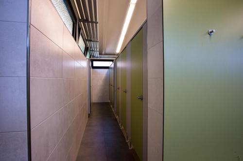 a hallway with green doors and tile walls at Vier Jahreszeiten Camping - Biggesee in Olpe
