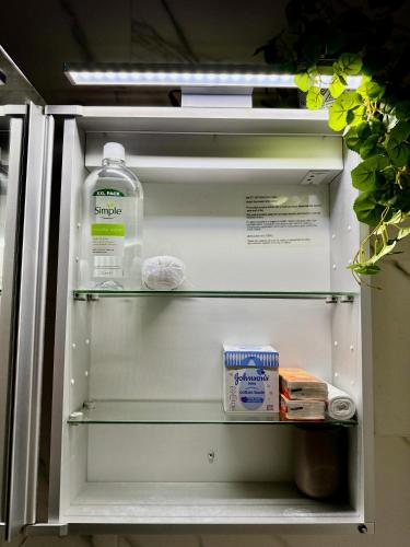 a refrigerator with a gallon of milk and a bottle of water at Superb Duplex in Hendon in The Hyde