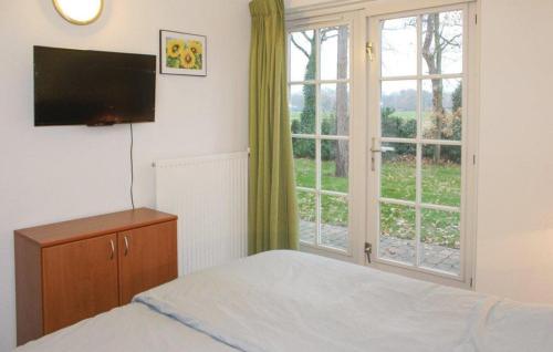 a bedroom with a bed and a large window at Buitengoed het Lageveld 55 in Hoge-Hexel