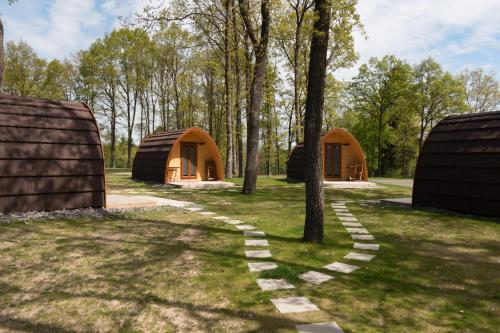 a path through a field with two yurt buildings at Vier Jahreszeiten Camping - Biggesee in Olpe