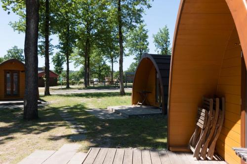 a wooden bench next to a building with trees at Vier Jahreszeiten Camping - Biggesee in Olpe