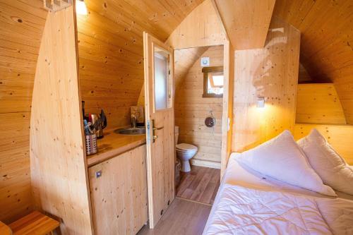 a bedroom with a bed in a wooden cabin at Vier Jahreszeiten Camping - Biggesee in Olpe
