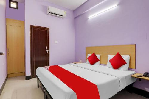 a bedroom with a large bed with red pillows at Hotel O SRV Palace in Lucknow
